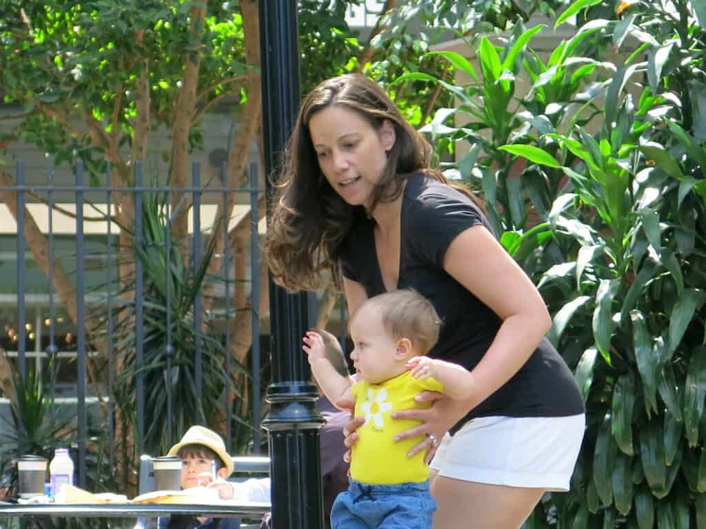 A mother of a young child together finding purpose with tress in the background. 