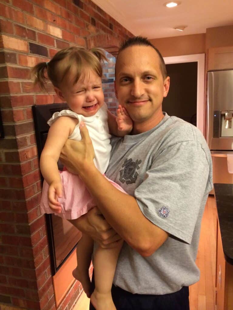Dad holding crying daughter